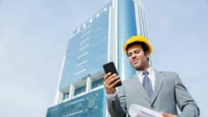Architect Standing Outdoors Holding Cell Phone